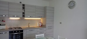 Una cocina moderna con estufa a gas, pileta y alacenas de madera.