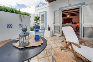 An outdoor seating area with a table, chairs, and a lantern.