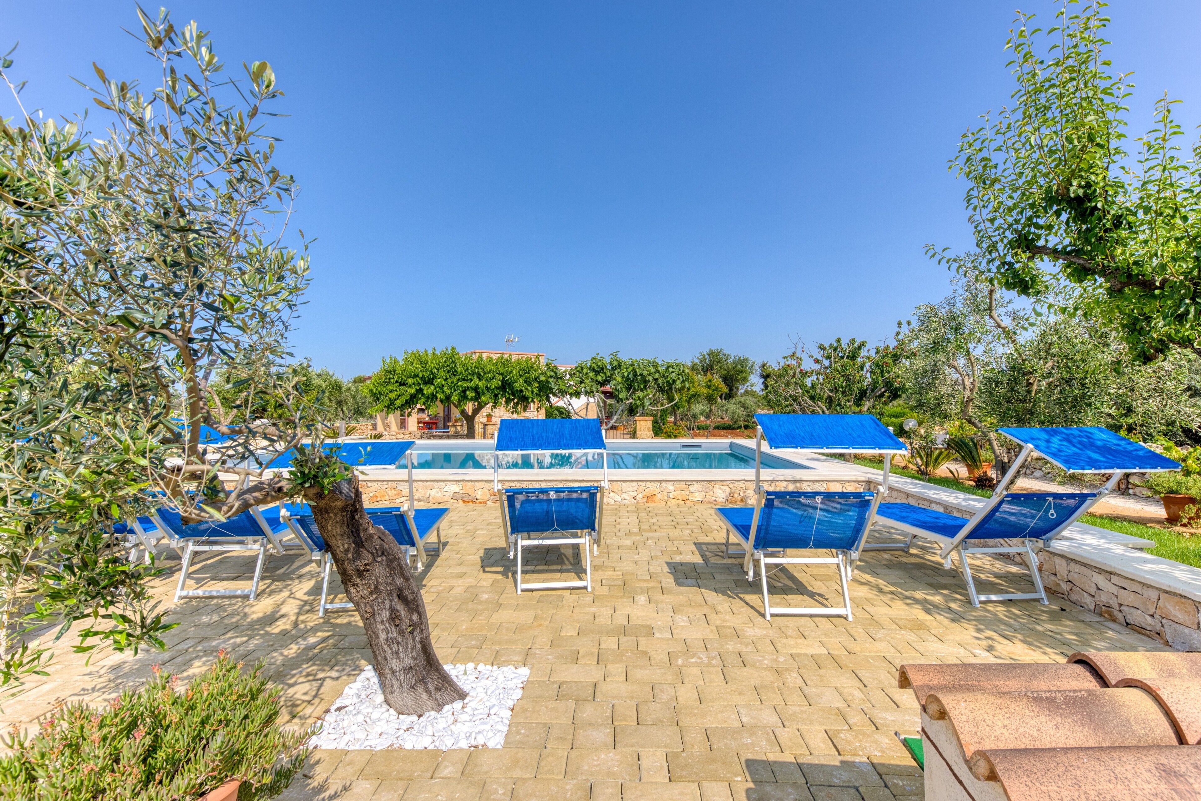 A poolside area with lounge chairs and a swimming pool.