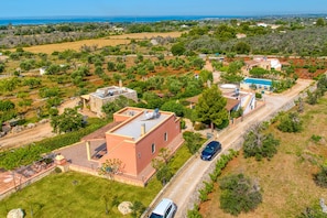 Vue aérienne d’une propriété dotée d’une piscine, d’un court de tennis et d  ’un vignoble.