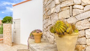 A stone wall, a white building, and two potted plants. - Holiday Home 'Villetta Cosimo' with Shared Pool, Private Garden and Air Conditioning (Morciano di Leuca)