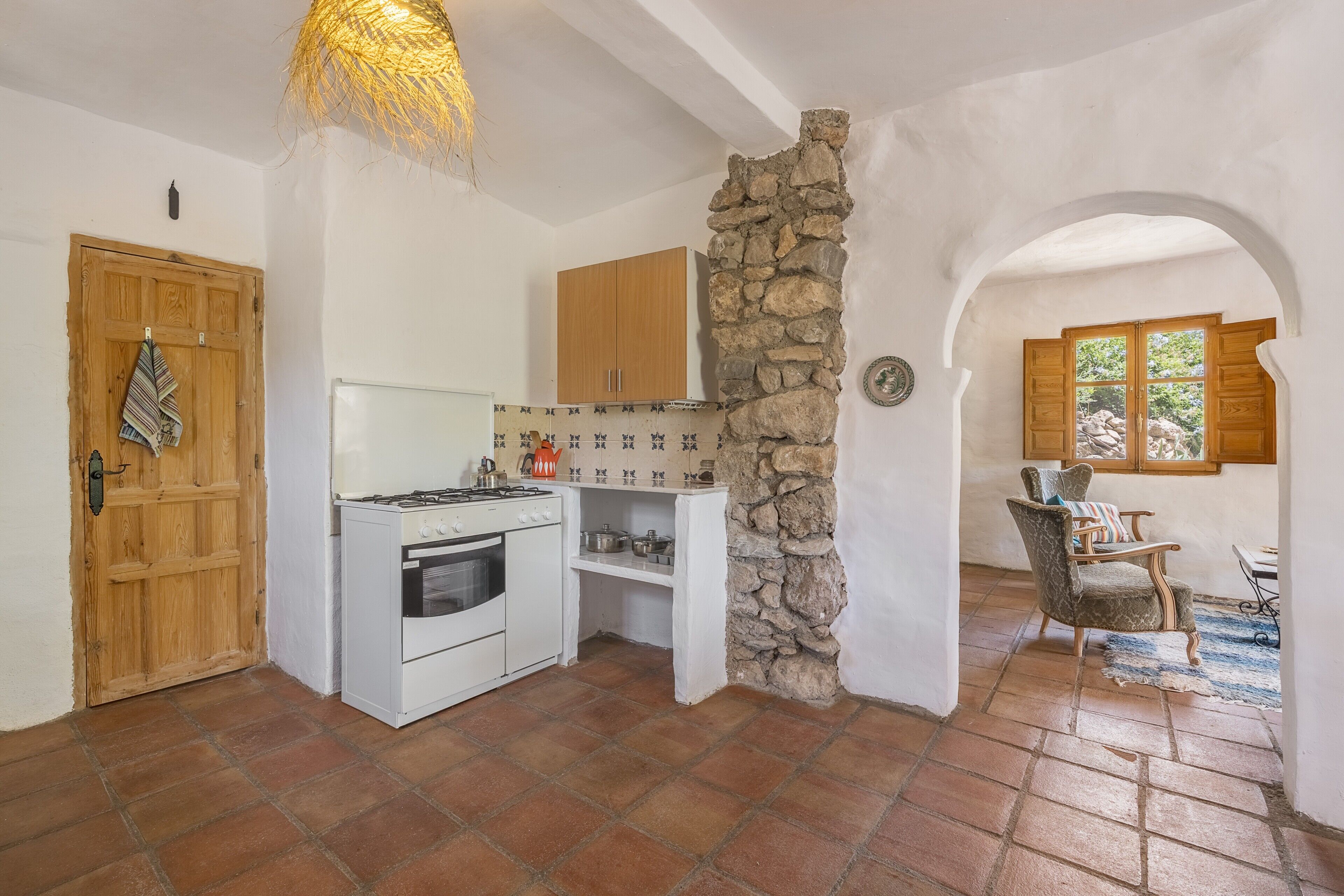 Una cocina con estufa, horno y armarios de madera.
