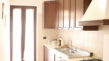 Køleskab, ovn, kaffe-/temaskine, køkkentøj/tallerkener/redskaber