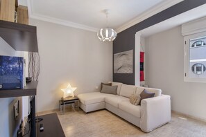Un salon moderne avec un canapé d’angle, une lampe en forme d’étoile et une œuvre d’art accrochée au mur.