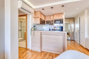 A modern kitchen with wooden cabinets, a central island, and an air conditioning unit.