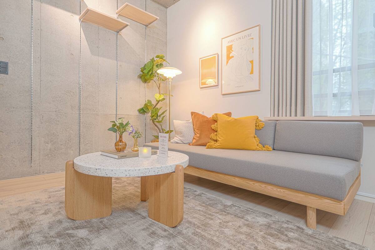 A modern living room with a grey sofa, wooden coffee table, and a floor lamp.
