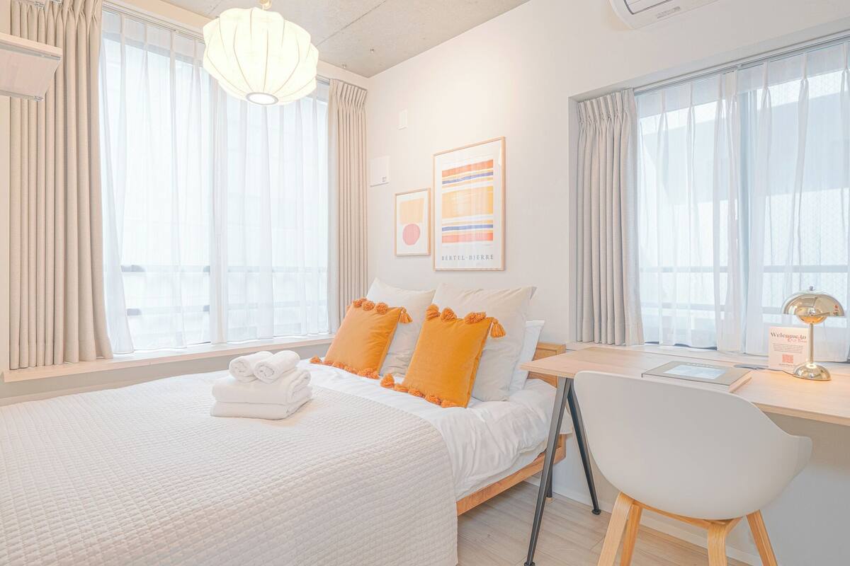 A modern hotel room with a large bed, a desk, and a chair.