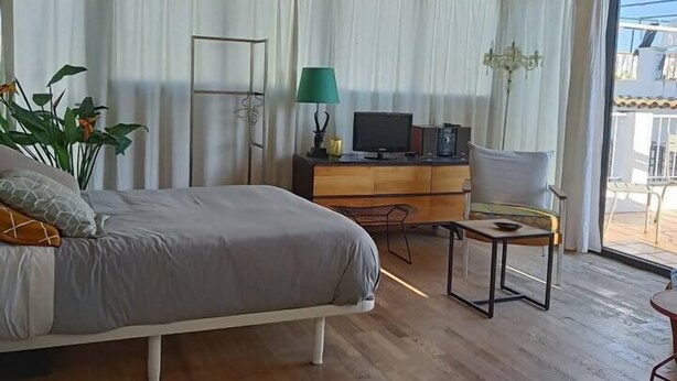 A modern bedroom with a bed, a desk, a chair, and a television. - Penthouse in Ciudad Vieja (Cordoba)