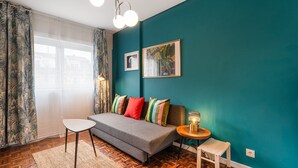 A cozy living room with a sofa, a small table, and a lamp.