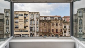 A view from a window overlooking a row of historic buildings with balconies and varied architectural styles.