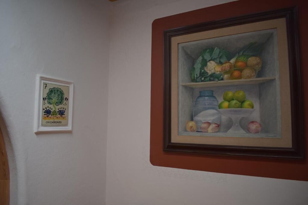 Un tableau encadré représentant une corbeille de fruits, accroché à un mur.