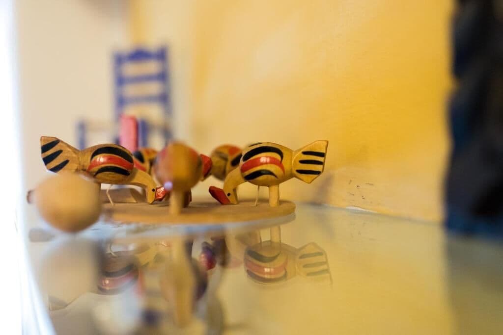 A wooden toy on a glass table with a blurred background.