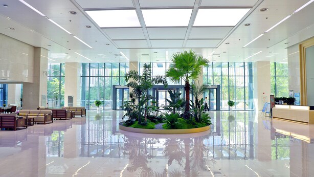 A spacious lobby with a central planter, large windows, and a reception desk. - Beijing CSN Pearl Hotel (Langfang)