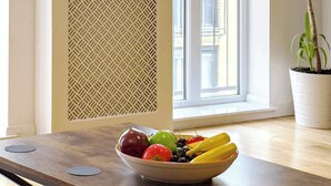 A room with a dining table, a bowl of fruit, a potted plant, and a window with a view of buildings. - Spacious 3BR Shoreditch ApartM, 2Baths, 2 Balconies 150 SqM Sleeps Family of 6 (Greater London)