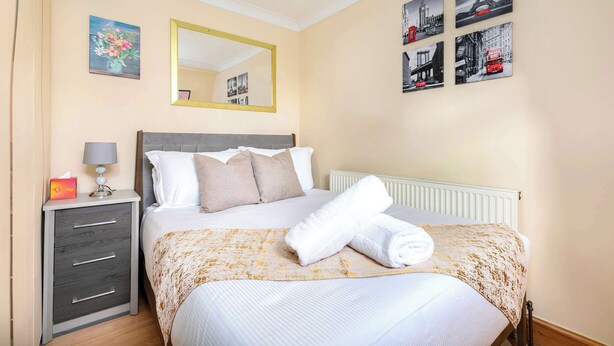 Une chambre d’hôtel avec un lit, une table de chevet, un miroir et des œuvres d’art murales.