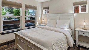 Une chambre à coucher avec un grand lit, deux tables de chevet et une fenêtre donnant sur l’extérieur.