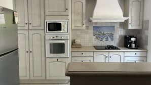 A kitchen with white cabinetry, a Bosch refrigerator, a microwave, an oven, a gas stove, and a coffee maker. - VILLA FOR 6 PEOPLE, PRIVATE POOL, NEAR BEACH, SAINTE-MAXIME (STE MAXIME)