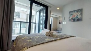 Ein Hotelzimmer mit Bett, großem Fenster und einem Gemälde an der Wand.