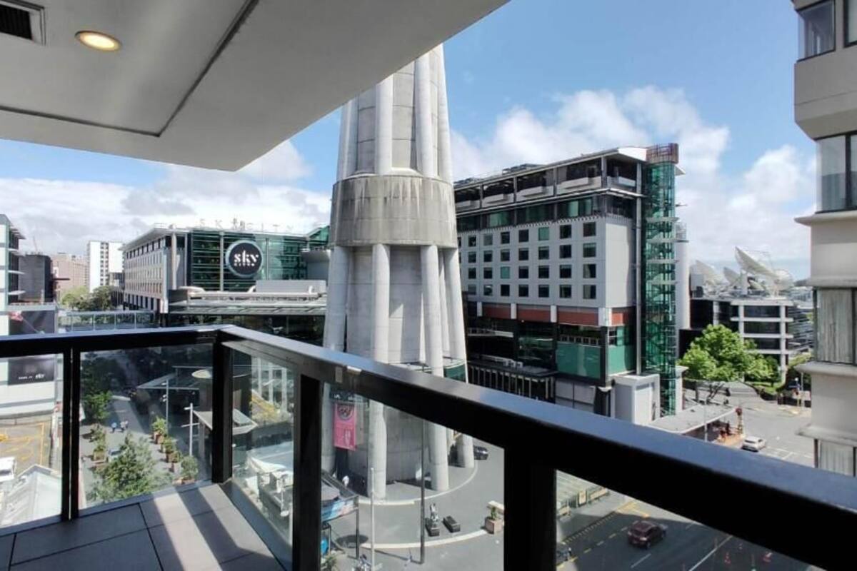 A modern building with a glass facade and a prominent cylindrical structure.