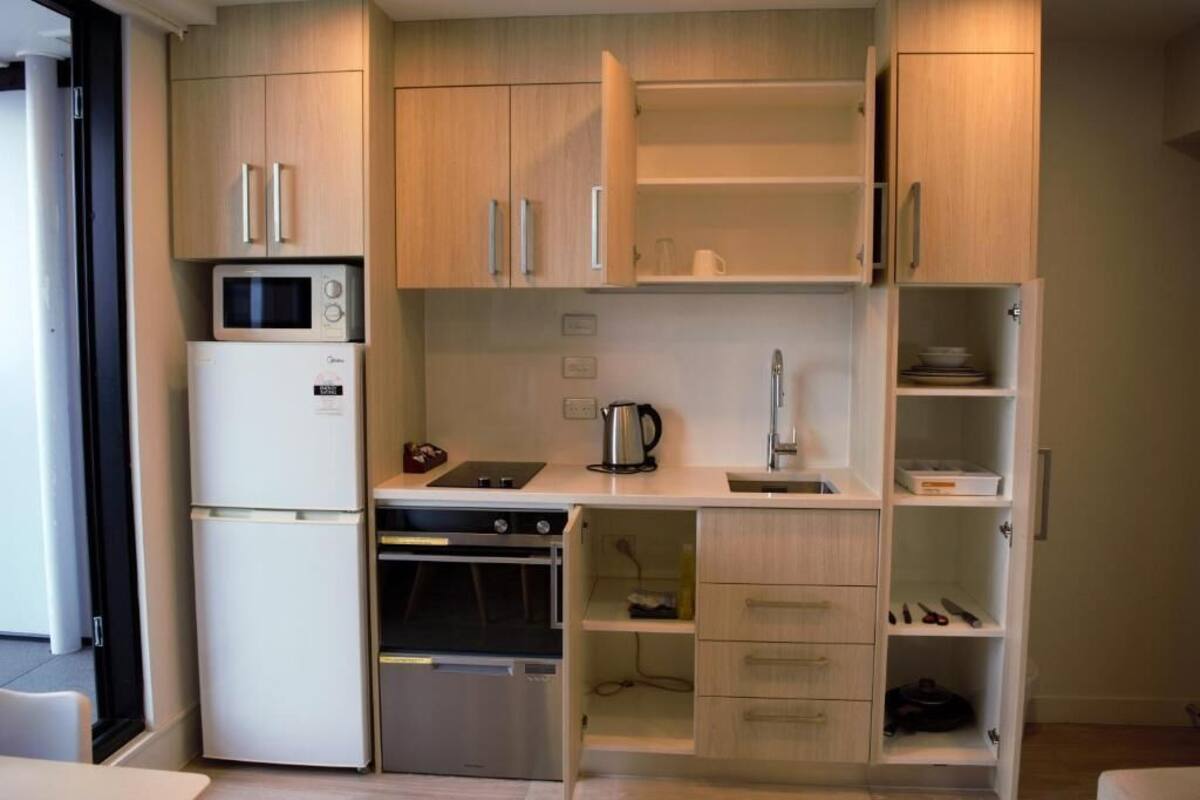 A compact kitchen with a microwave, oven, and dishwasher.