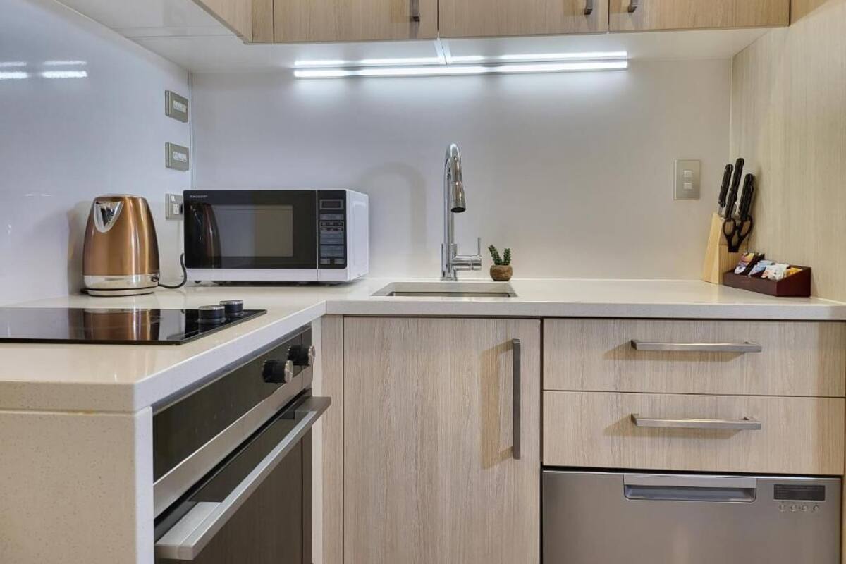 A modern kitchen with a microwave, stove, and dishwasher.