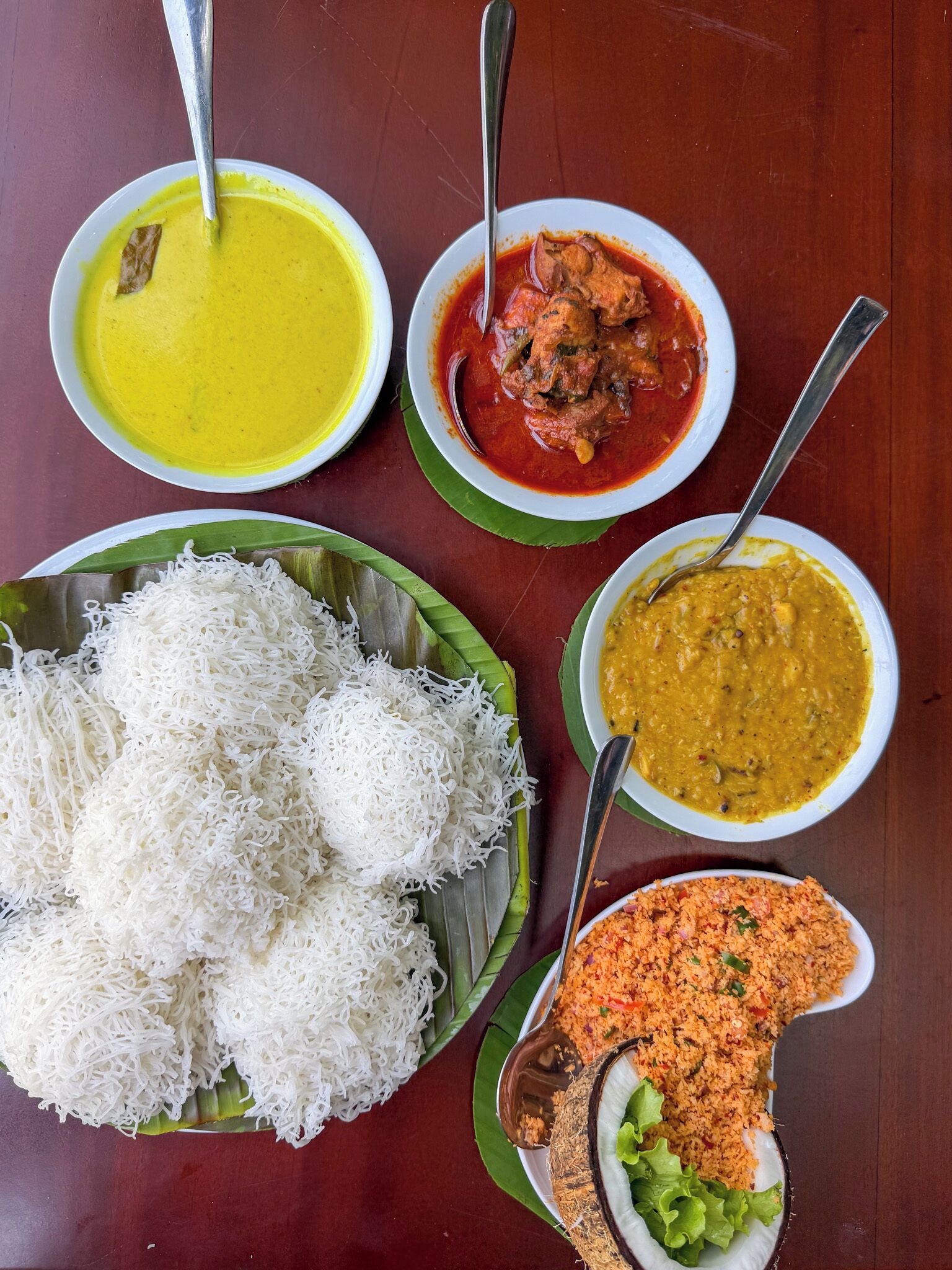 Una mesa con diversos platos, incluyendo arroz, curry y un tazón de lentejas.