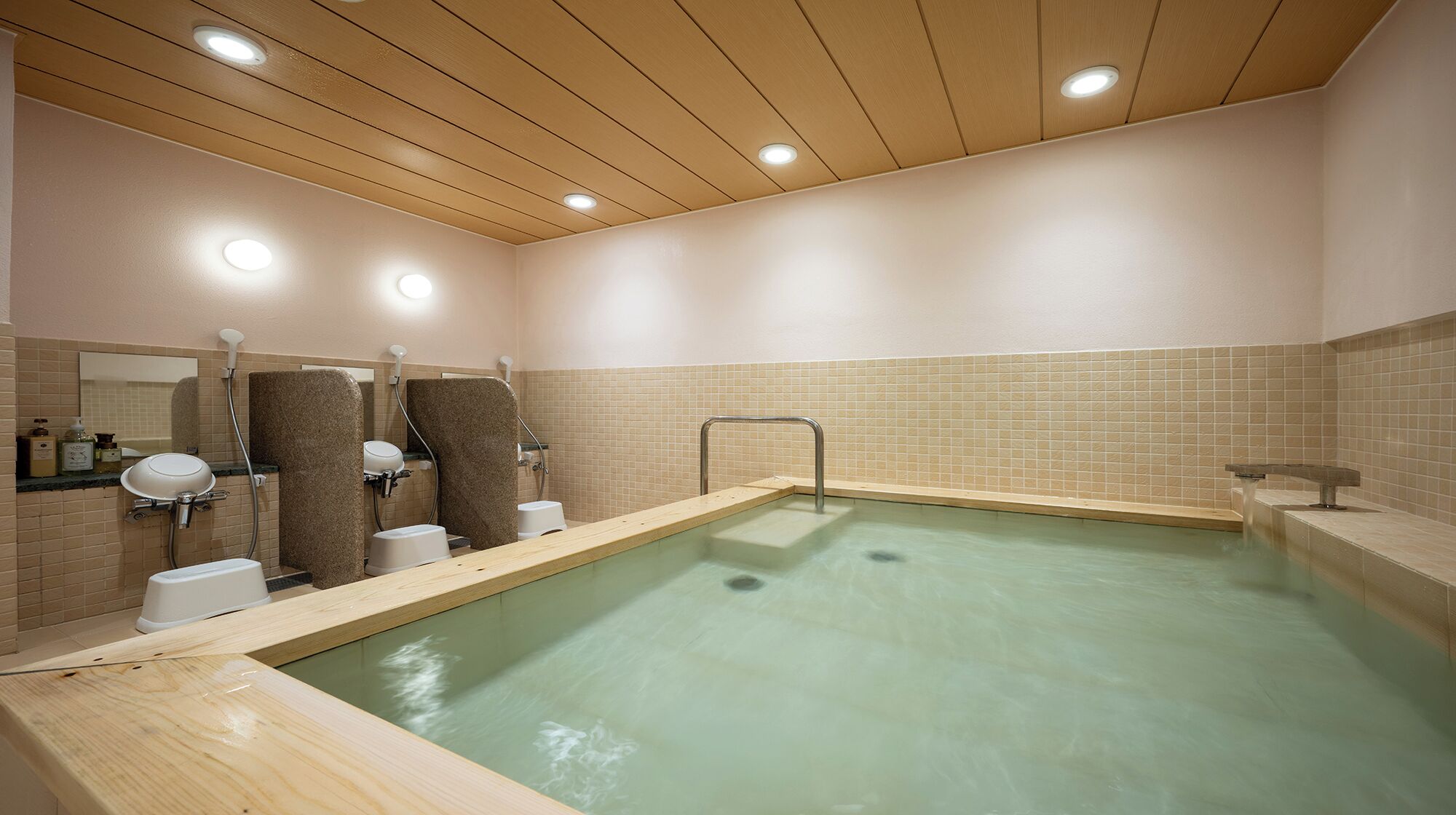 Piscina com teto de madeira, paredes azulejadas e corrimão de metal.