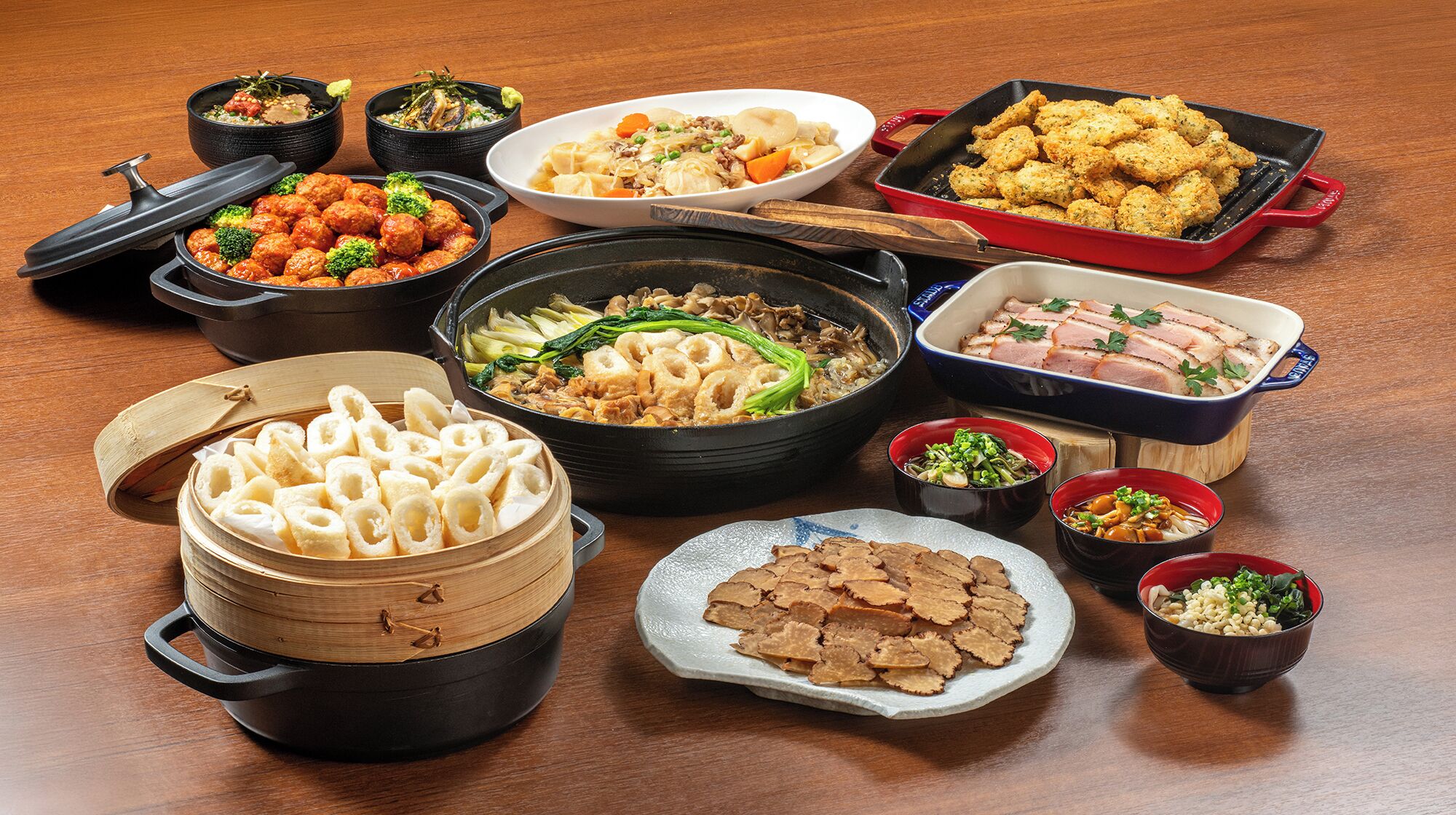 A variety of dishes and cookware on a wooden table.