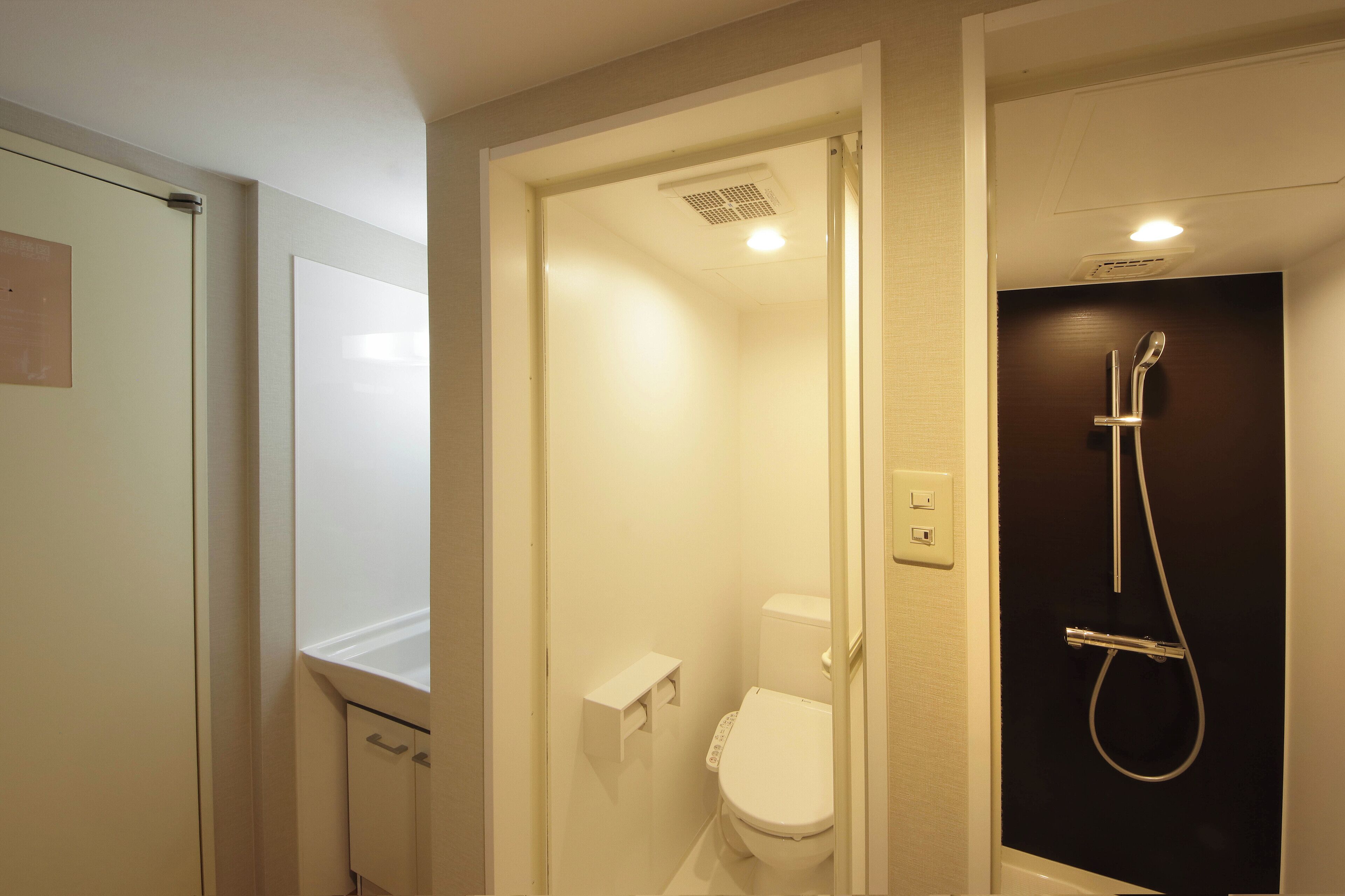 Un baño con inodoro, ducha y un armario.