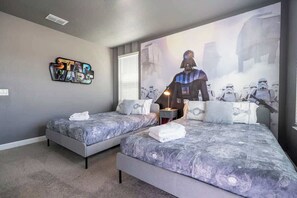 A bedroom with two beds, a Star Wars themed wall, and a Star Wars poster. - Stunning 5-Bedroom Home with Pool (Kissimmee)