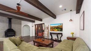 A living room with a large green sofa, a wooden coffee table, and a fireplace.