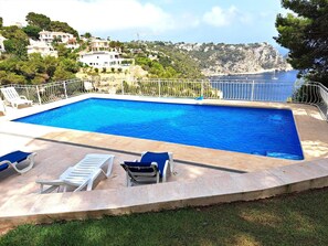 A rectangular swimming pool with a white metal fence, surrounded by lounge chairs and a stone deck. - Maria 10 in J vea With 5 Bedrooms and 3 Bathrooms (Javea)
