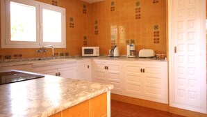 A kitchen with white cabinets, a marble countertop, a microwave, a toaster, and a coffee maker. - Maria 10 in J vea With 5 Bedrooms and 3 Bathrooms (Javea)