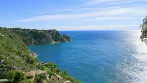 A coastal landscape with a clear view of the sea, a rocky coastline, and buildings on the hillside. - Maria 10 in J vea With 5 Bedrooms and 3 Bathrooms (Javea)