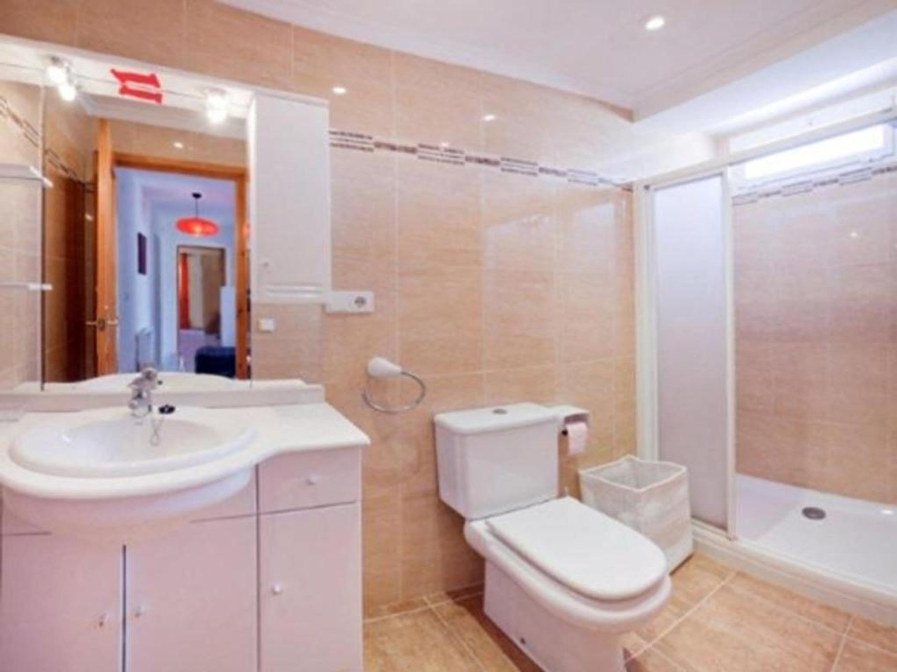 Un baño moderno con lavamanos, inodoro y ducha.