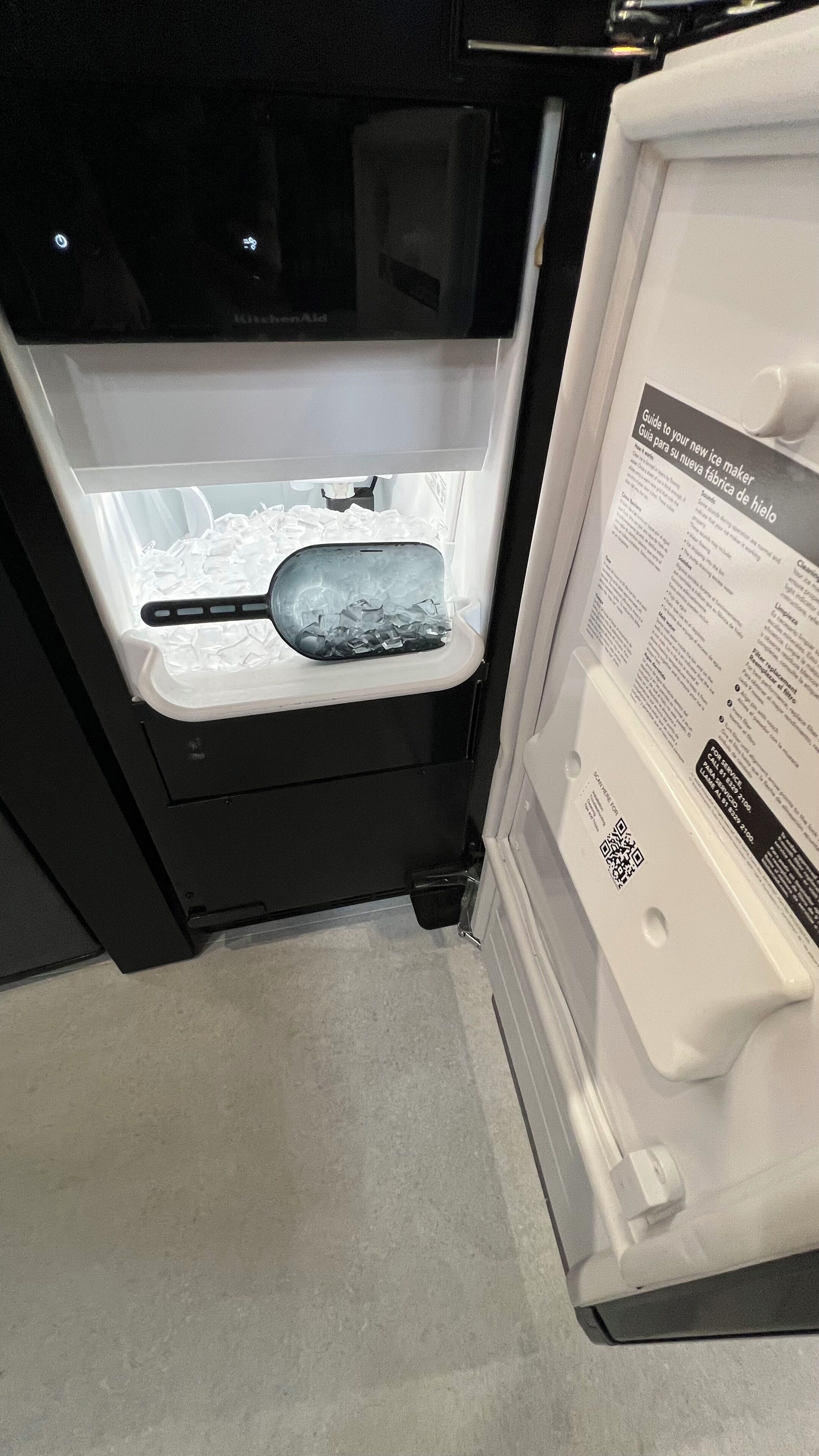 A refrigerator with a freezer compartment containing ice and a tray.