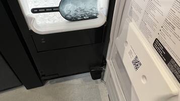 A refrigerator with a freezer compartment containing ice and a tray.