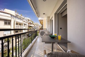 A balcony with a table, a chair, and a bowl with a drink. - Marbella Living Pangrati By O&O Group  (Athens)