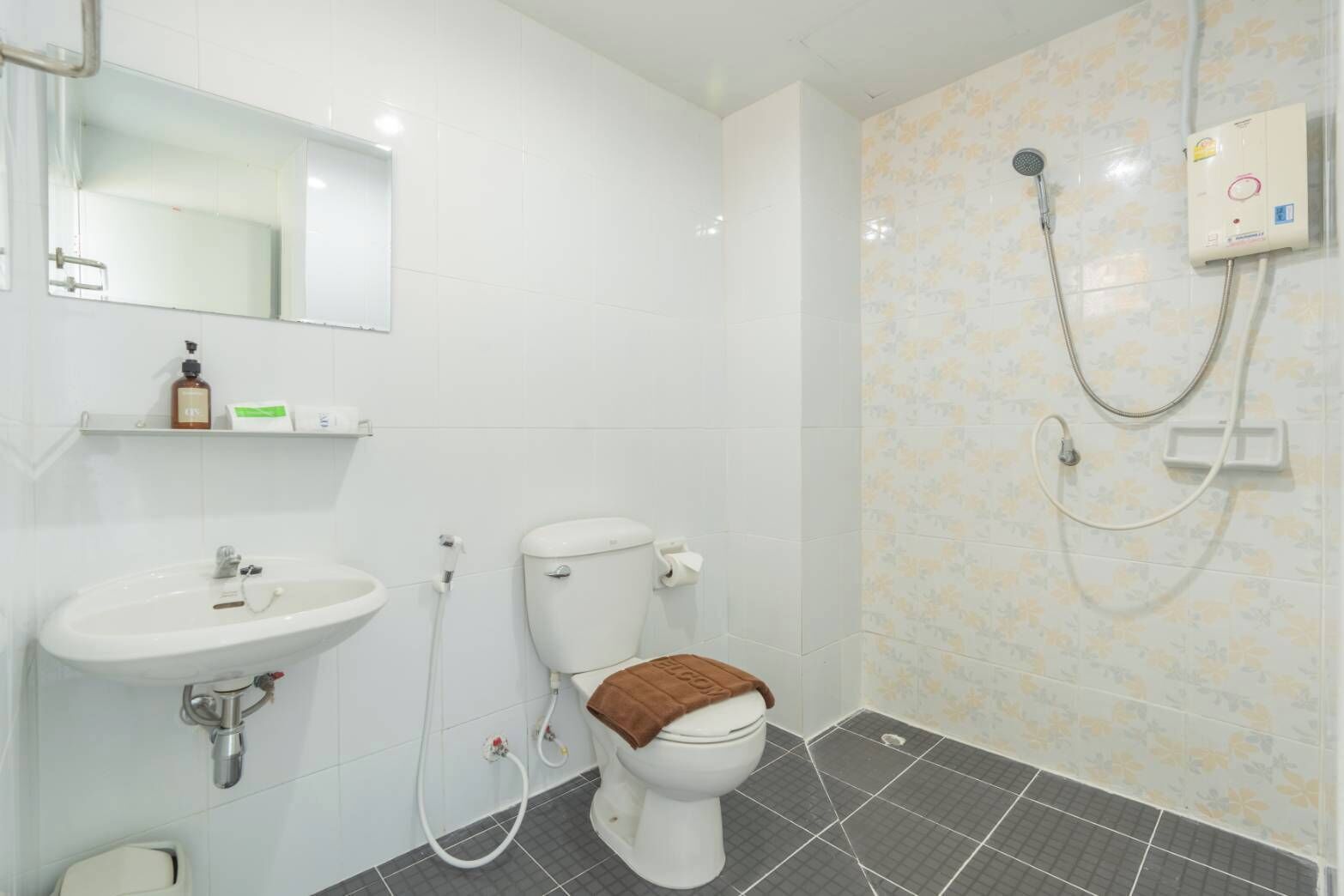 Une salle de bain équipée de toilettes, d’un lavabo et d’une douche.