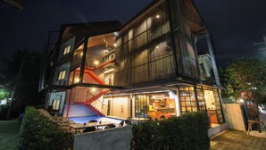 Een modern gebouw met een zwembad, terras en een trap.