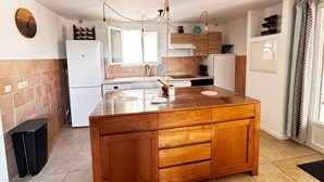 A kitchen with a wooden island, white appliances, and a tiled backsplash. - La Villa Maquis, VILLA MAQUIS (Bonifacio)