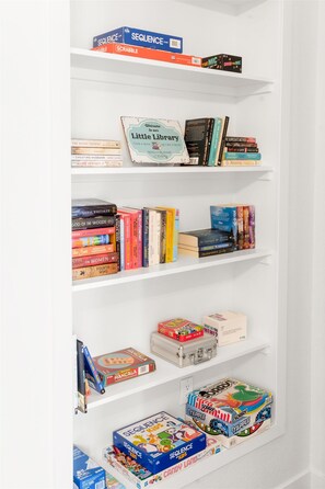 Een boekenplank met verschillende boeken en gezelschapsspellen.