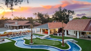 Un resort con piscina, zona de estar al aire libre y vistas al atardecer.