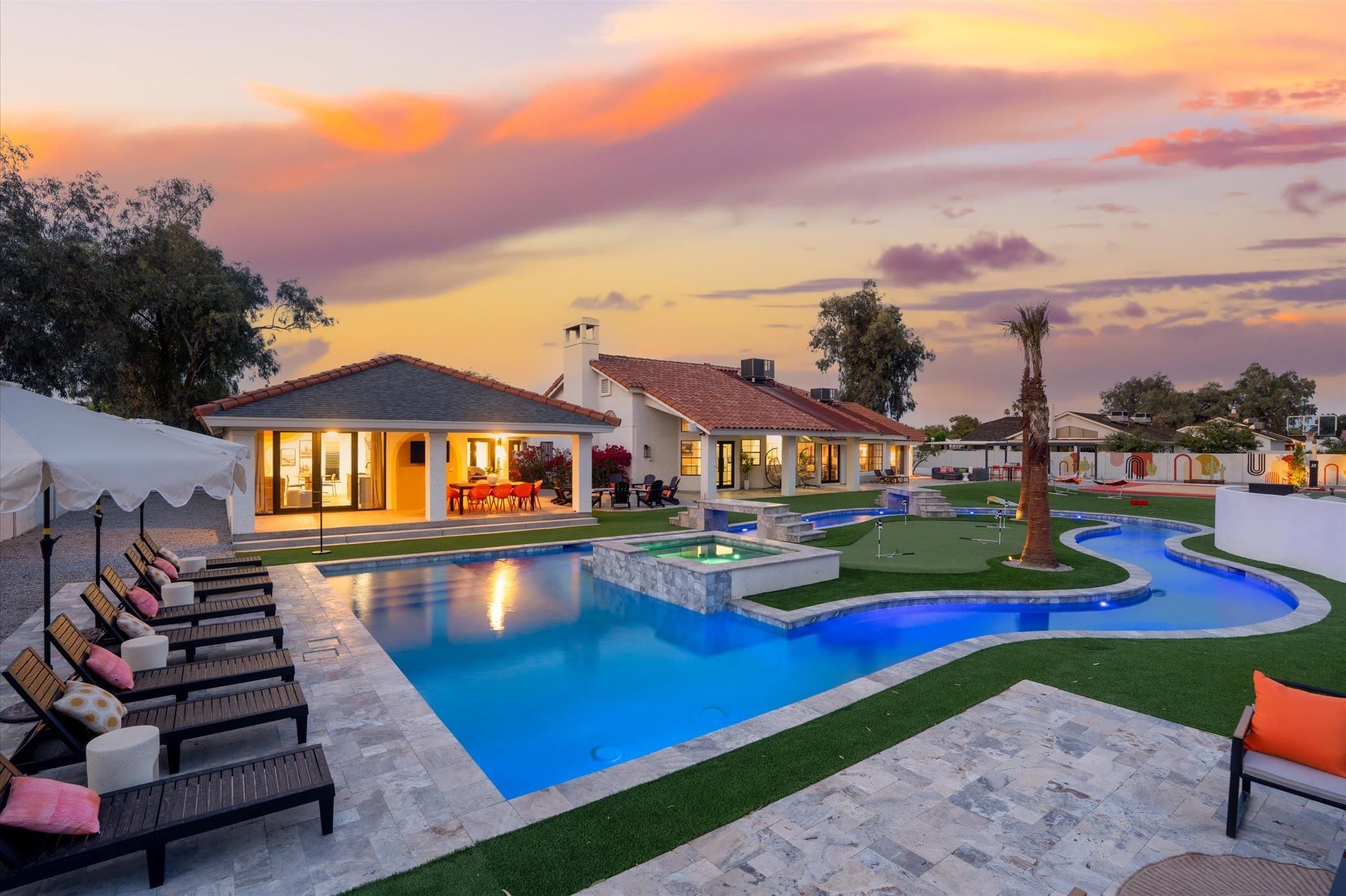 A pool area with lounge chairs and a landscaped garden.