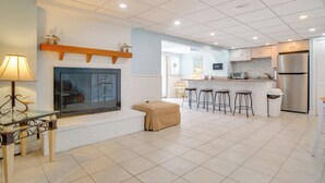 Una cocina moderna con una isla central, taburetes de bar, horno empotrado y refrigerador de acero inoxidable.