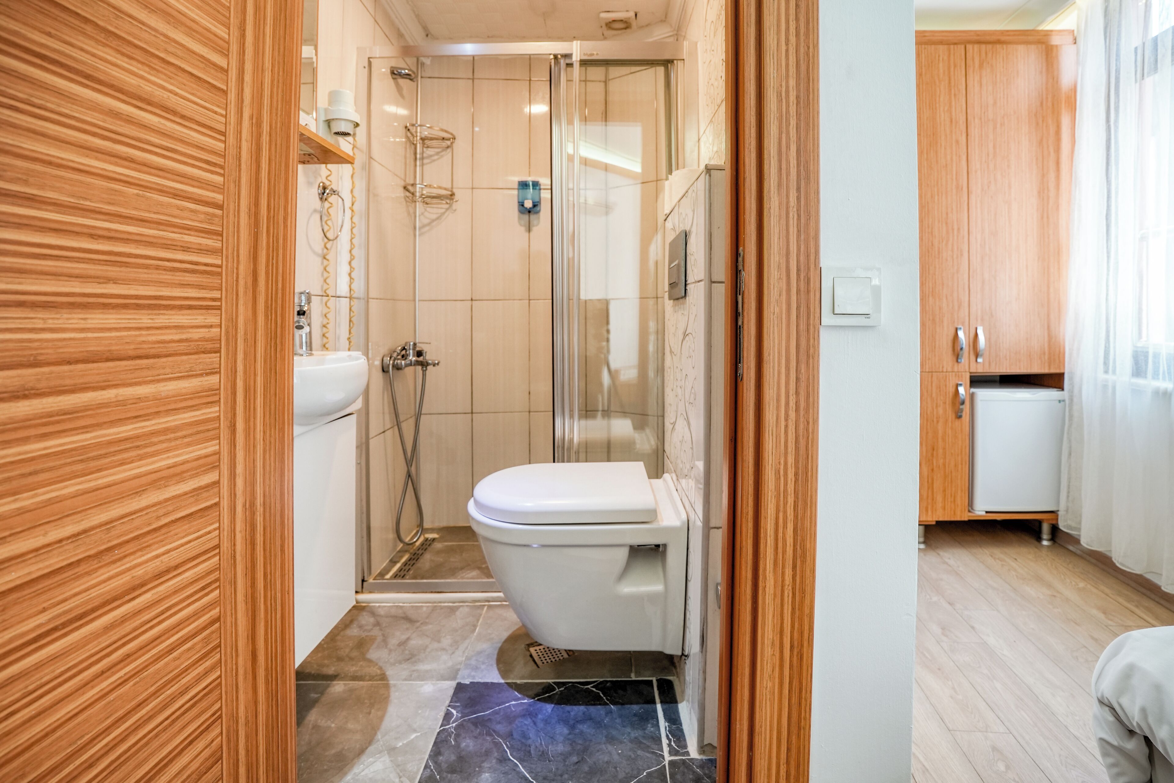 A compact bathroom with a toilet, shower, and sink.