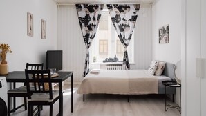 A minimalist bedroom with a bed, a desk, and a chair.