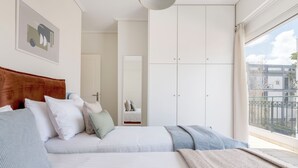 A bedroom with two beds, a wooden headboard, and a large wardrobe. - Refined 2BR Apartment in Marousi (Marousi)