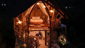 Una estructura de madera tipo A acogedora, con un balcón y una escalera que conduce a la entrada.
