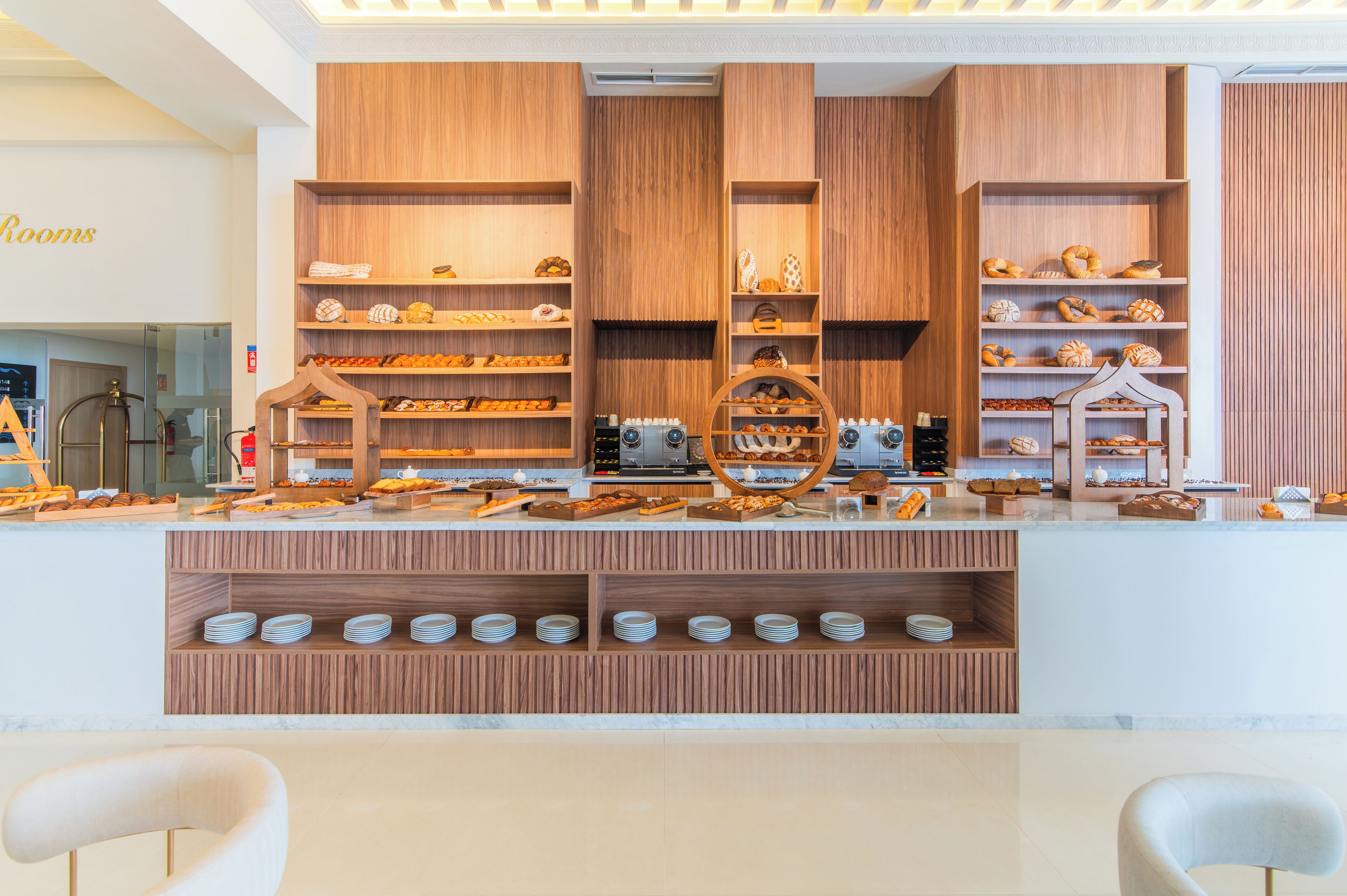 A bakery display with various baked goods and a coffee station.